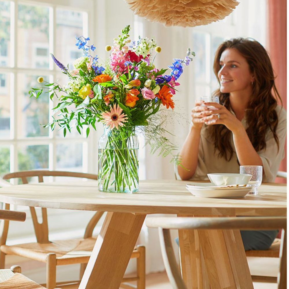 Een blije vrouw die geniet van een zojuist ontvangen boeket bloemen